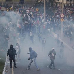 People throw tear gas back at police as they protest outside Minerao stadium where a Confederations Cup soccer match takes place between Japan and Mexico in Belo Horizonte, Brazil, Saturday, June 22, 2013. Demonstrators once again took to the streets of Brazil on Saturday, continuing a wave of protests that have shaken the nation and pushed the government to promise a crackdown on corruption and greater spending on social services. 