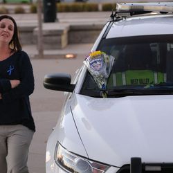Mandy Richards brings flowers to the patrol car of her nephew, West Valley police officer Cody Brotherson, outside the police station in West Valley City on Monday, Nov. 7, 2016. Brotherson was killed in the line of duty Sunday.