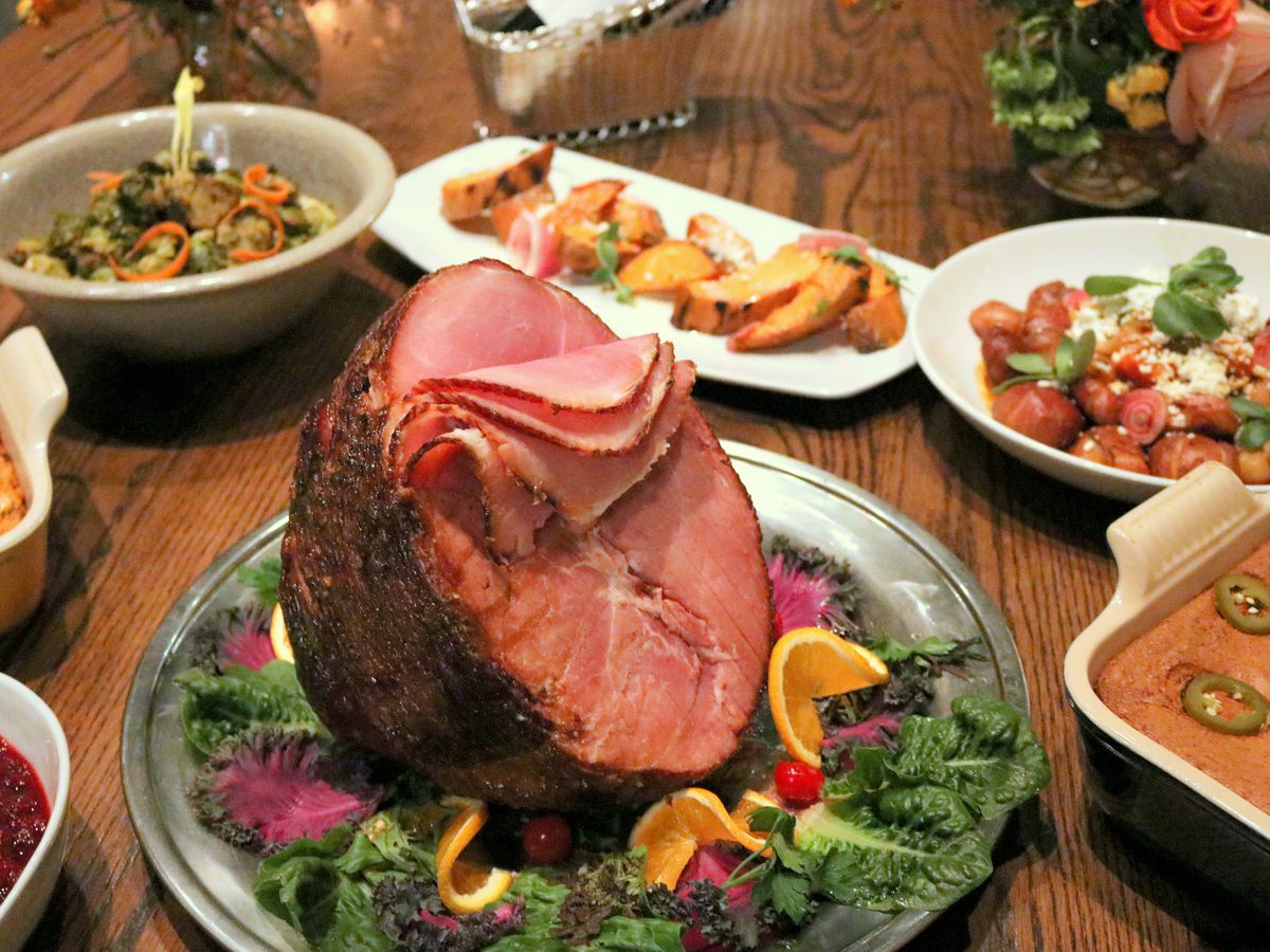 Hugo’s spiral ham on a platter surrounded by various sides, including jalapeno cornbread and cranberry sauce.