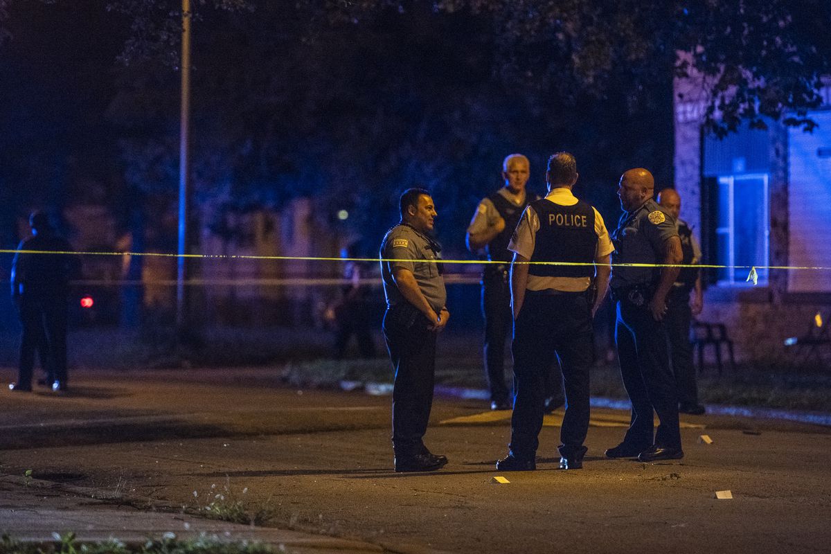 Police investigate the scene where two girls, 11 and 17, were shot Sunday night in the 11700 block of South Perry Street. | Tyler LaRiviere/Sun-Times