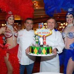 Buddy Valastro and Daniel Boulud flanked by two showgirls. 