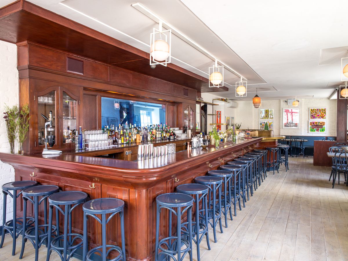 The wooden bar with blue stools at Grand Army.