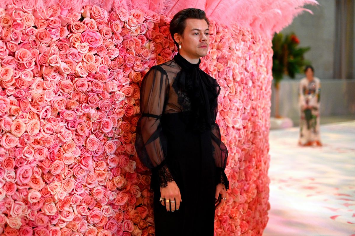 Harry Styles stands against a wall of roses at the 2019 Met Gala.