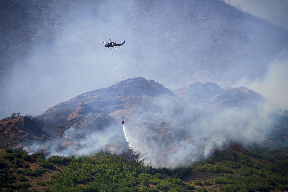 A helicopter drops fire retardant on the East Canyon Fire as it burns north of East Canyon State Park, on Tuesday, June 8, 2021, near Morgan, Utah.