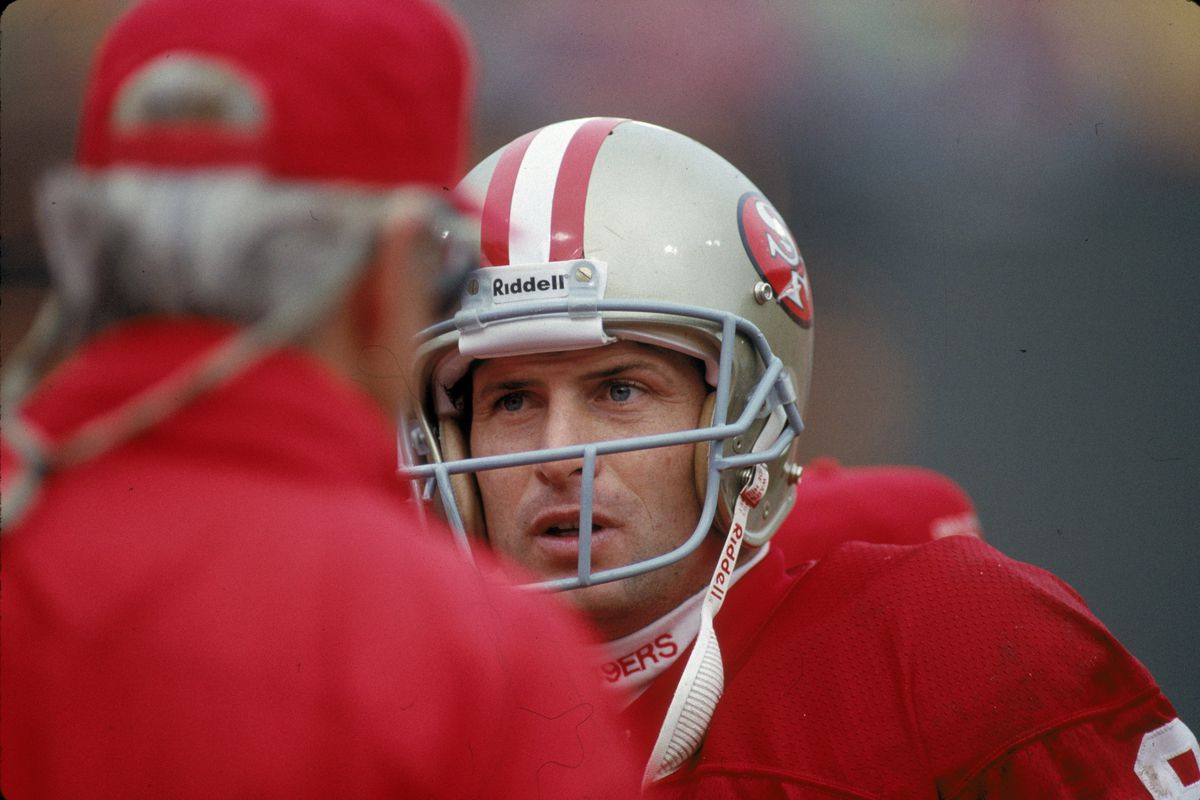 Quarterback Steve Young of the San Francisco 49ers confers with head coach George Seifert on the sideline against the Dallas Cowboys in the 1992 NFC Championship Game at Candlestick Park on January 17, 1992 in San Francisco, California. The Cowboys defeated the 49ers30-28.
