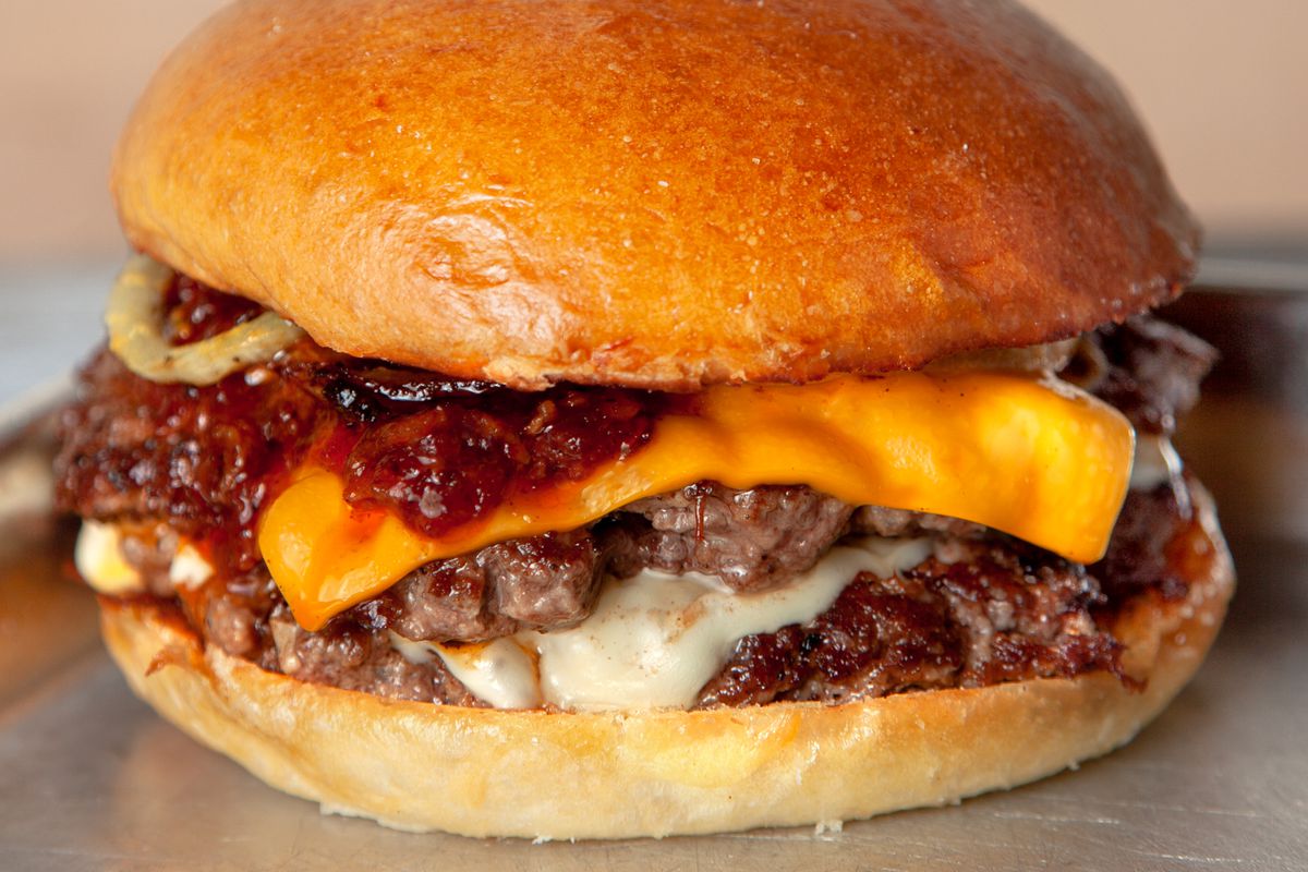 A burger with sauce, cheese, and patty