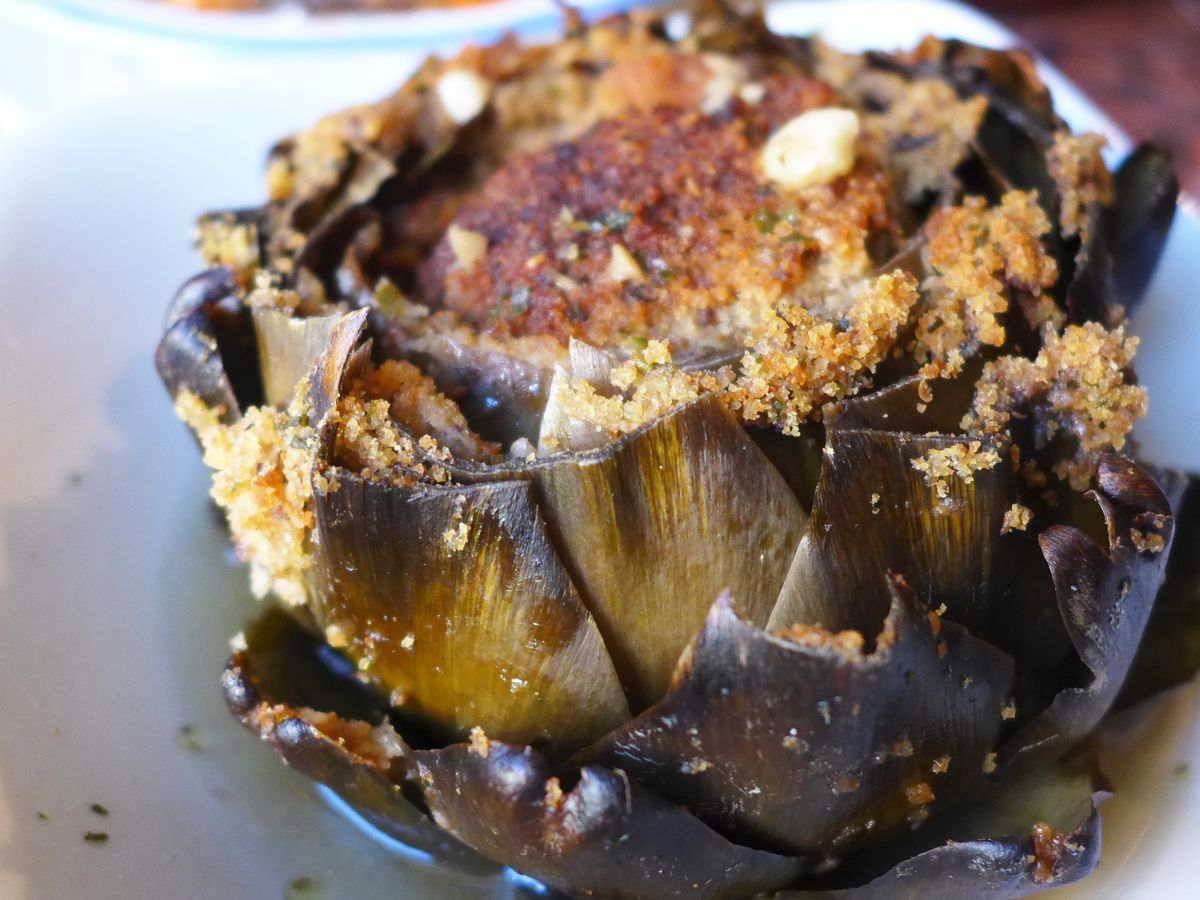 A huge artichoke baked to near blackness with crumbs on top.