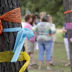 Faculty and parents gather outside Lemm Elementary School after placing ribbons on the trees in honor of those killed in a multiple shooting Thursday, July 10, 2014, in Spring, Texas. Some of the victims were students at the school. The Harris County Sheriff's Office says Ronald Lee Haskell was booked Thursday on a capital murder/multiple murders charge and held without bond. Authorities believe Haskell fatally shot two adults and four children on Wednesday night and critically wounded a 15-year-old girl, who called 911.