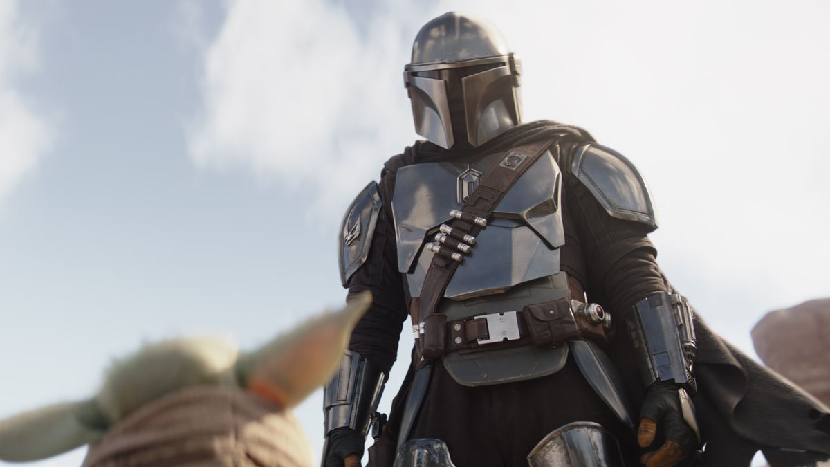 The Mandalorian looks down at the pointy ears of Grogu in a shot from season 3 of The Mandalorian