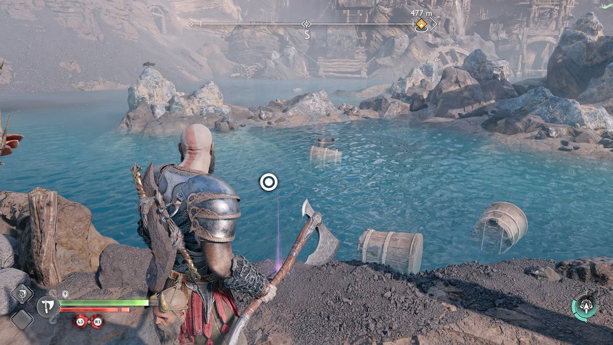 Kratos looks at an Artifact while standing next to a large body of water