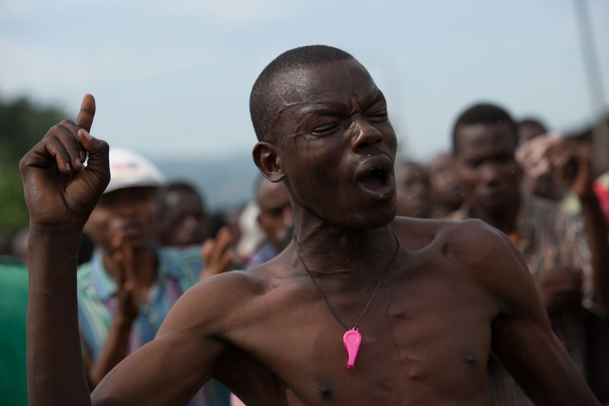 A Burundian protestor shouts at the army for bulldozing a barricade.