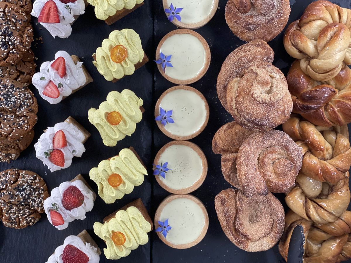 An overhead photo of seasonal pastries from Orange &amp; Blossom vegan patisserie at a farmer’s market stand
