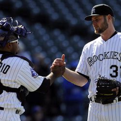 Colorado Rockies starting pitcher Chris Volstad (31) celebrates with catcher Wilin Rosario (20) after defeating the New York Mets 11-3 in a baseball game on Thursday, April 18, 2013, in Denver. 