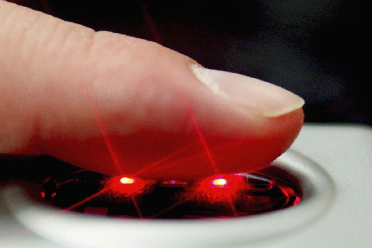 Someone’s finger is scanned by a fingerprint scanner