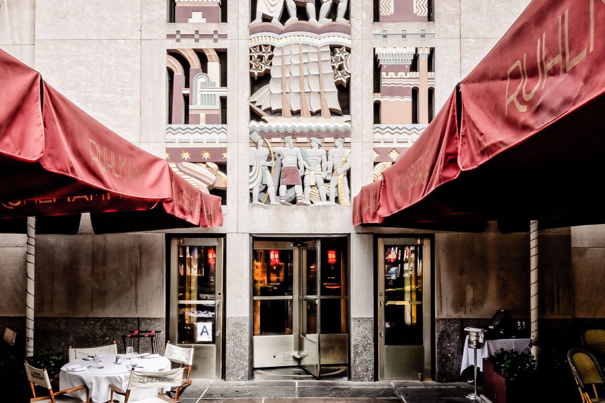 The entrance of Brasserie Ruhlmann in an art deco building with red awnings