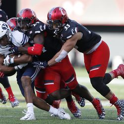 Brigham Young wide receiver Jonah Trinnaman, left, is tackled by Cincinnati safety Malik Clements (24) and linebacker Jaylyin Minor (33) during the first half of an NCAA college football game, Saturday, Nov. 5, 2016, in Cincinnati. (AP Photo/Gary Landers)