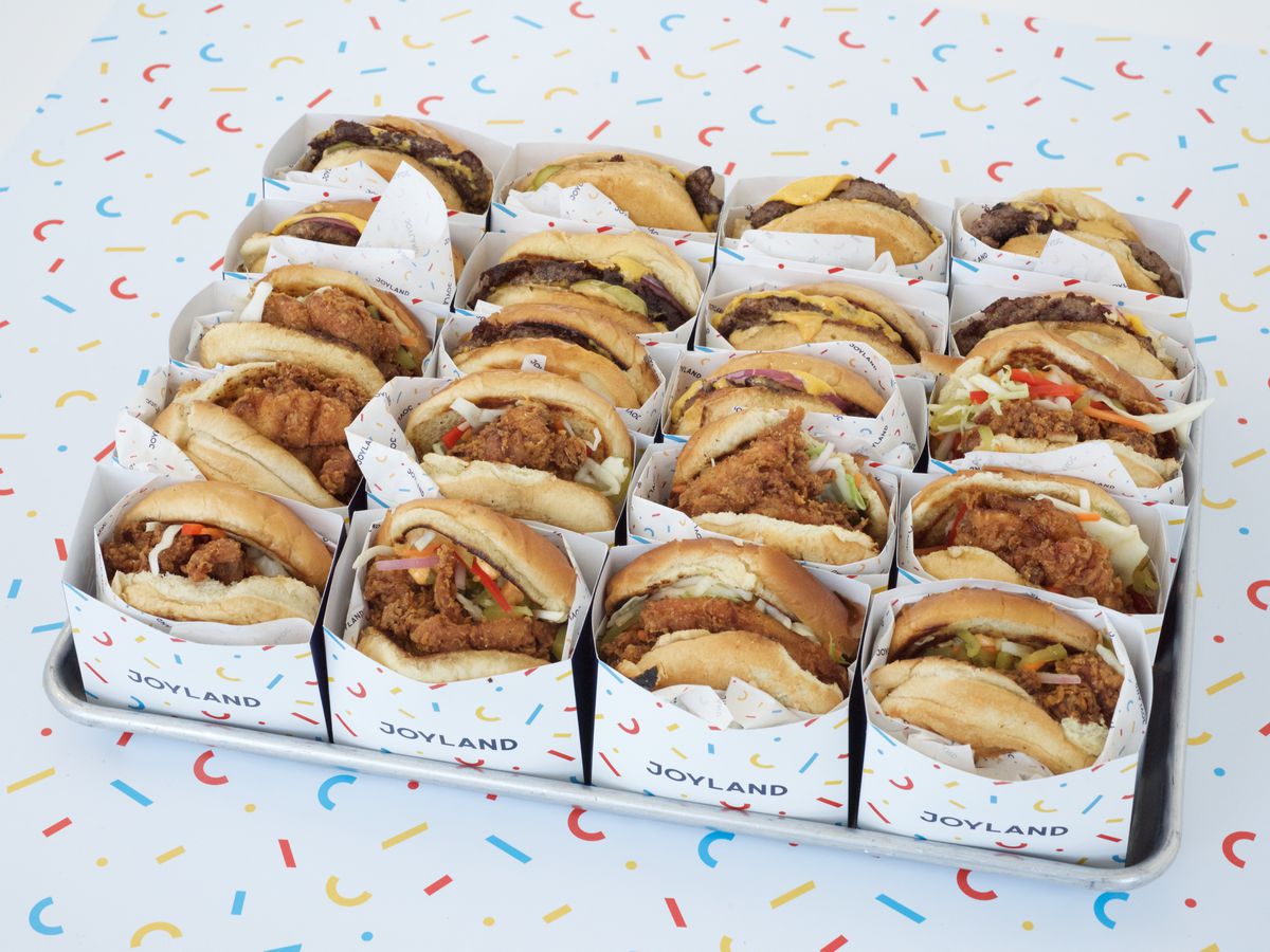 a tray full of assorted burgers and chicken sandwiches