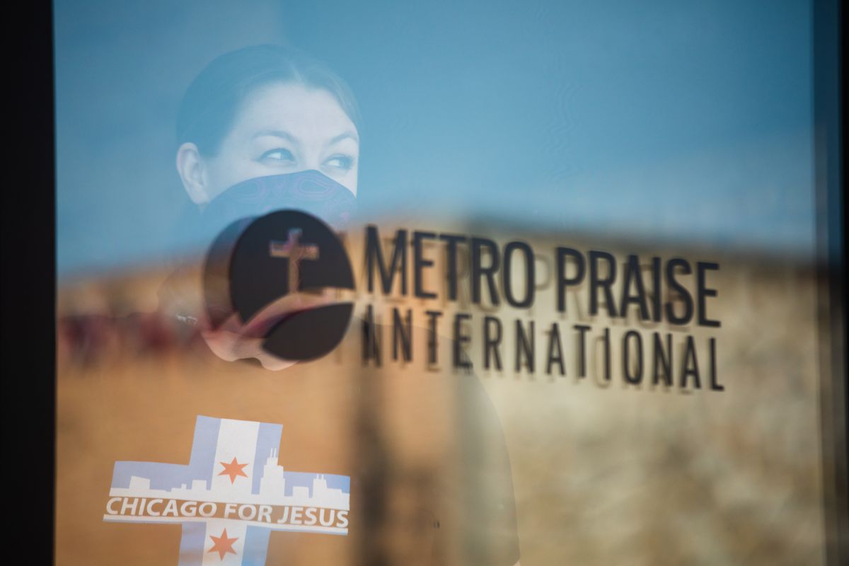 A member of Metro Praise International stands by the door of the church as a service take place on May 24, 2020. The church is one of the churches across Chicago that are defying Gov. J.B. Pritzker’s shelter-in-place order, which limits in-person worship to 10 people. | Pat Nabong/Sun-Times
