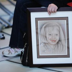 A photo is held of a child during Utah World Rare Disease Day in the Capitol rotunda in Salt Lake City Friday, Feb. 27, 2015. 