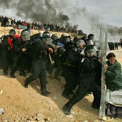 A Jewish settler struggles with an Israeli security officer during clashes that erupted as authorities evacuated the West Bank settlement outpost of Amona, east of the Palestinian town of Ramallah, Feb. 1, 2006. Thousands of troops in riot gear and on horseback clashed with hundreds of stone-throwing Jewish settlers holed up behind barbed wire and on rooftops in this illegal West Bank settlement outpost, after the Supreme Court cleared the way for the demolition of nine homes at the site.