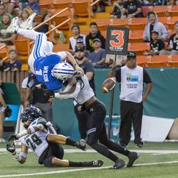 BYU quarterback Zach Wilson (1) loses the football on a hit by Hawaii defensive back Eugene Ford, right, as Wilson tried to leap into the end zone during the second half of the Hawaii Bowl NCAA college football game Tuesday, Dec. 24, 2019, in Honolulu. Hawaii recovered the football in the end zone for a touchback.
