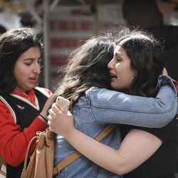 Friends embrace after shots were fired during the Toronto Raptors NBA basketball championship parade in Toronto, Monday, June 17, 2019. (Andrew Lahodynskyj/The Canadian Press via AP)