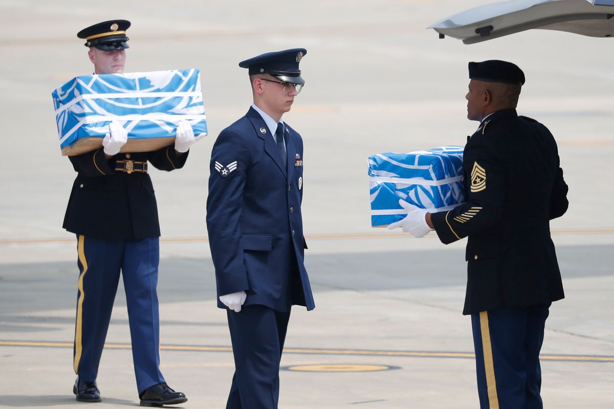 Soldiers carry caskets containing remains of US troops who were killed in the Korean War during a ceremony at Osan Air Base in Pyeongtaek on July 27, 2018.
