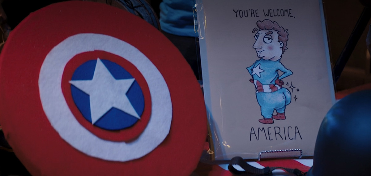 A screenshot from an episode of Ms. Marvel, showing a cartoon card with Captain America displaying a big ol’ bubble butt to the camera, with the words “You’re welcome, America”