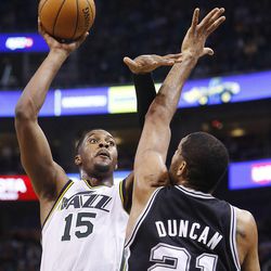Utah Jazz's power forward Derrick Favors (15) puts up a shot over Spurs' Time Duncan as the Utah Jazz and the San Antonio Spurs play Saturday, Dec. 14, 2013 at EnergySolutions Arena in Salt Lake City. The Spurs won 100-84.