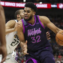 Minnesota Timberwolves center Karl-Anthony Towns (32) dribbles the ball while defined by Utah Jazz center Rudy Gobert (27) at Vivint Smart Home Arena in Salt Lake City on Thursday, March 14, 2019.