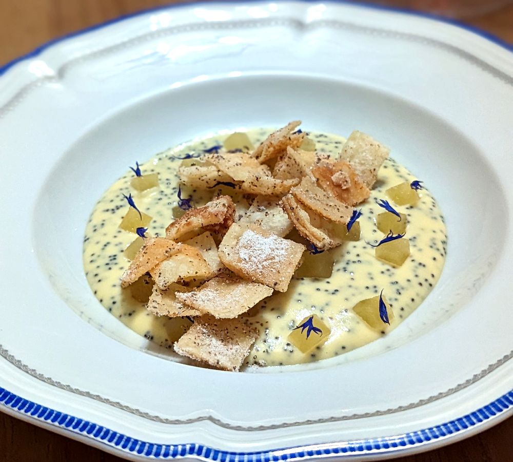 A soup-like dish topped with rectangular crisps.