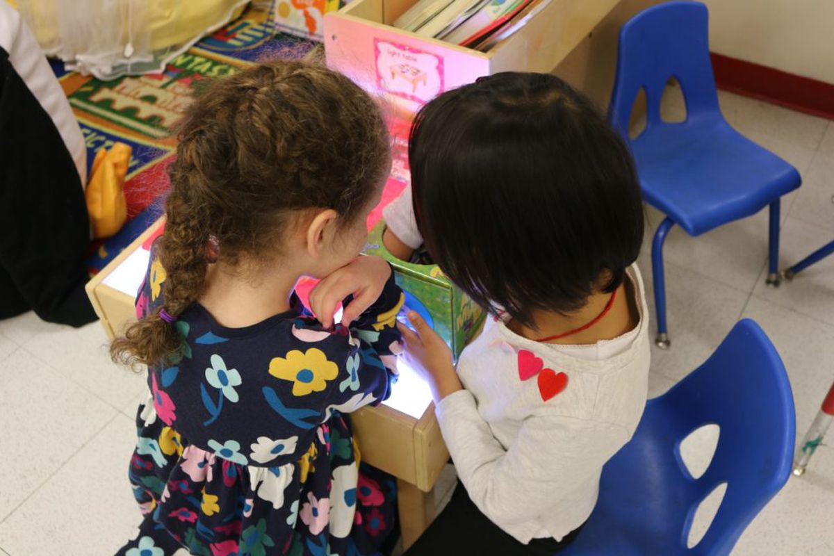 Pre-K students play at a light table at The Renaissance Charter School in Jackson Heights.