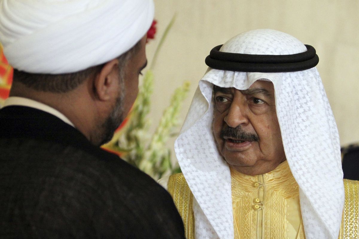 In this Dec. 21, 2010, file photo, Bahraini Prime Minister Khalifa bin Salman Al Khalifa speaks with opposition parliament member Sheik Hassan Sultan after the opening session of the new parliament in Manama, Bahrain. 