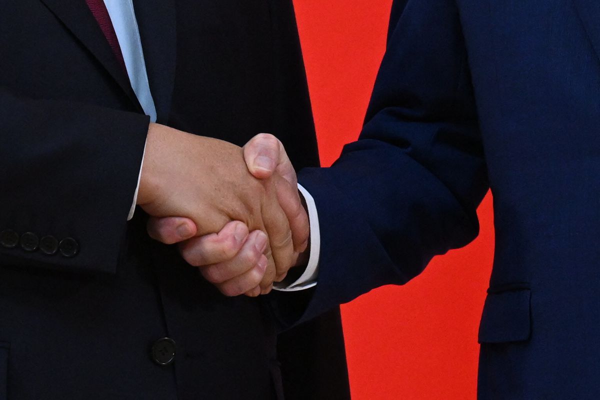 Closeup of two men in suits shaking hands.