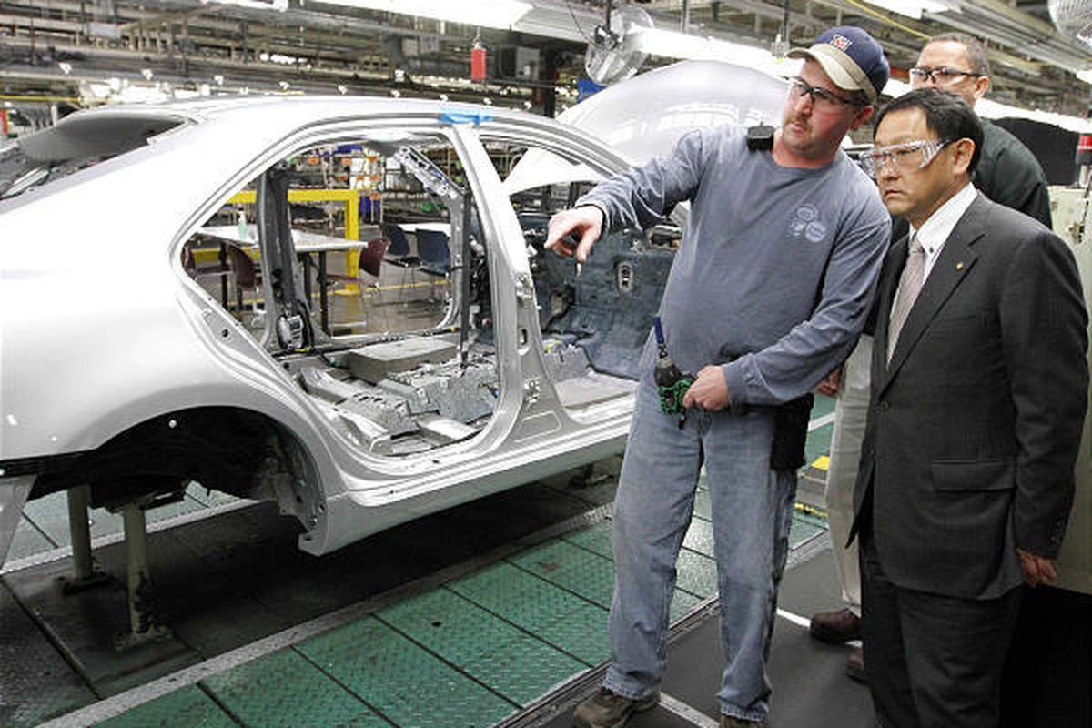 Toyota President Akio Toyoda, right, and production team member Bobby Parks look over the assembly line at the Toyota Motor Manufacturing plant in Georgetown, Ky., on Thursday.