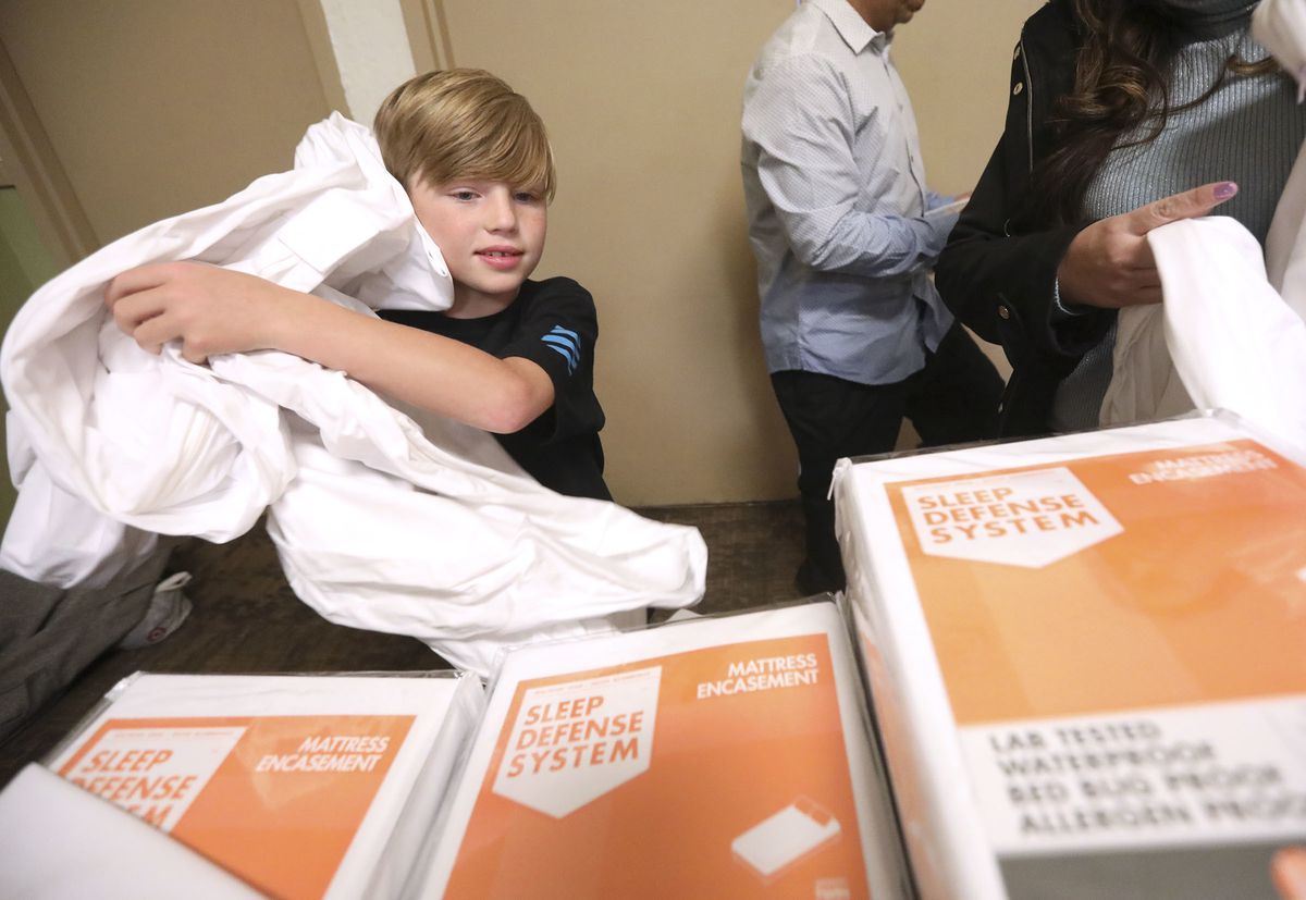 Chase Hansen, 9-year-old CEO of Kid Labs and a Leesa “social changemaker,” helps unwrap mattress covers at the Rescue Mission of Salt Lake on World Homeless Day in Salt Lake City on Wednesday, Oct. 10, 2018. Leesa Sleeps donated 150 mattresses to the miss