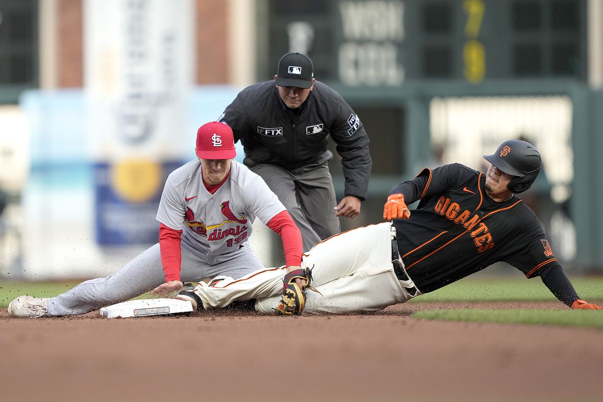 Wilmer Flores sliding into second base as the Cardinals apply a tag