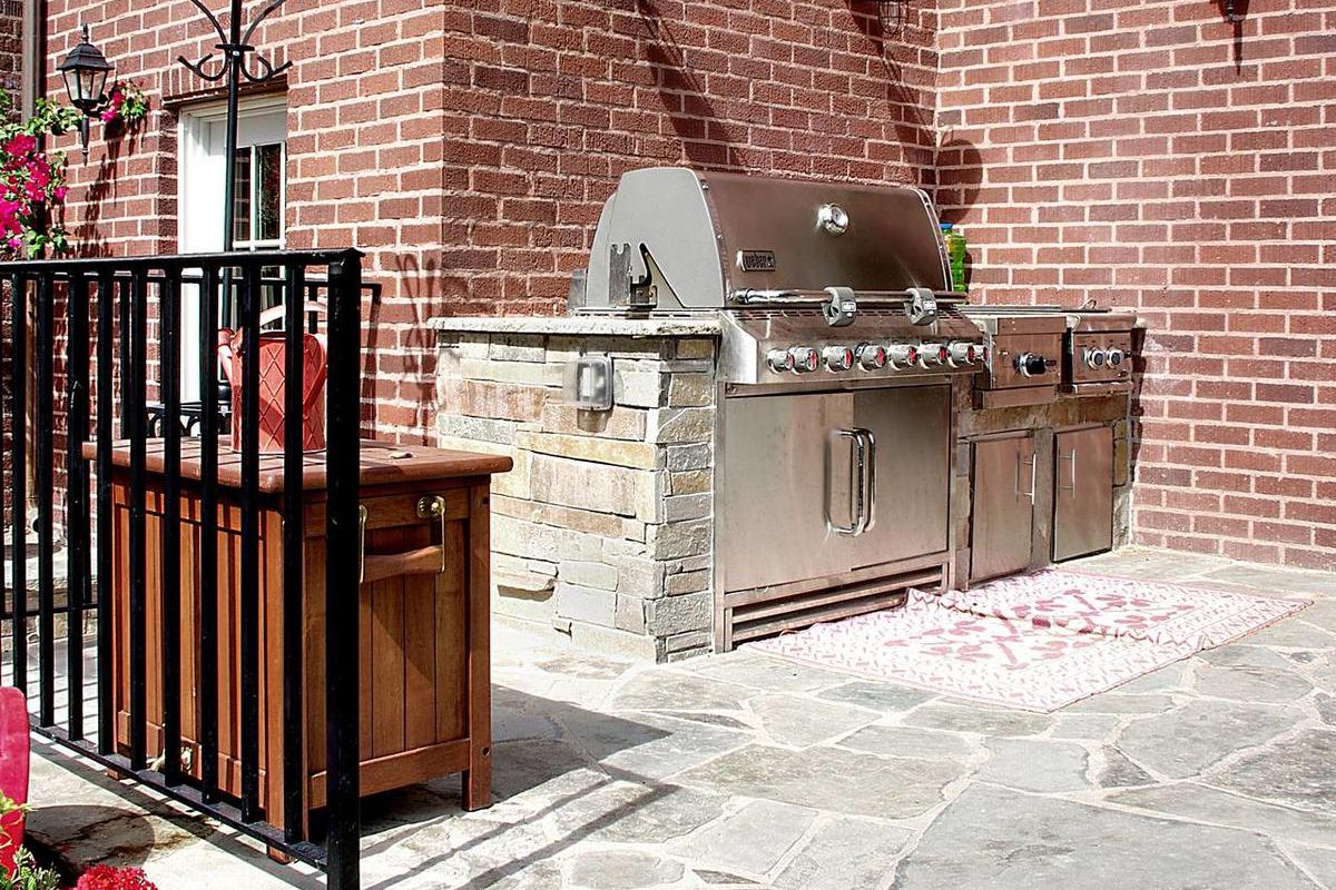Adding a barbecue built into a countertop and a food preparation area turns a simple patio into an outdoor kitchen.