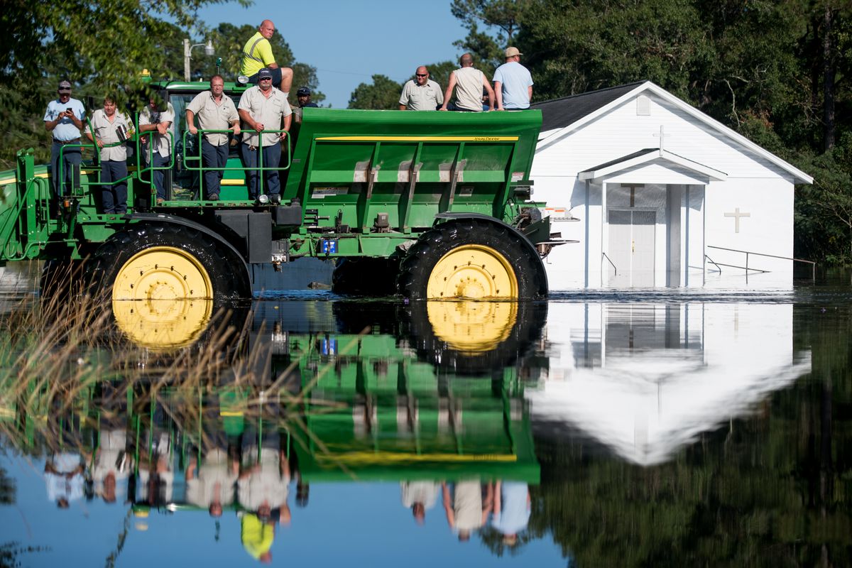 Workers uses farm machinery to navigate floodwaters from the Waccamaw River caused by Hurricane Florence in Bucksport, South Carolina.