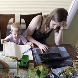 In this Wednesday, June 27, 2018, photo, Caely Barrett, who is part of a small group of stay-at-home mothers working to organize an immigration rally, works on her laptop next to her 18-month-old son in Portland, Ore. The small group of mothers organizing Saturday's rally in Portland to coincide with Families Belong Together rallies nationwide, are working almost around-the-clock to pull together an event expected to attract 5,000 people. (AP Photo/Don Ryan)