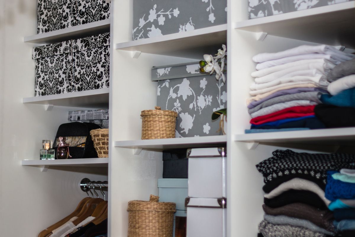 A smartly organized closet with shelves and a portion for hanging clothes.