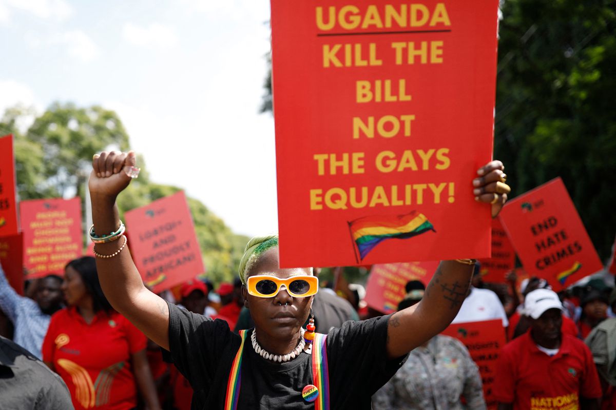 Protestor holds up red protest sign. Sign reads: Uganda — Kill the Bill Not the Gays. Equality!