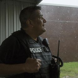 Lt. Javier Ramos, of the Port Lavaca Police Department, looks up at the rain while other officers eat barbecue chicken on Friday, Aug. 25, 2017. The officers were unable to respond to emergencies after winds reached 40 mph. Hurricane Harvey smashed into Texas late Friday, lashing a wide swath of the Gulf Coast with strong winds and torrential rain from the fiercest hurricane to hit the U.S. in more than a decade.