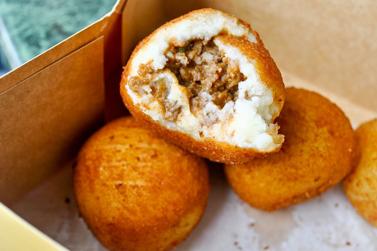 Potato balls open to reveal meat inside from a Cuban bakery.