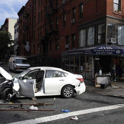 A car damaged in an accident sits in the middle of the street in the East Village section of New York, Wednesday, June 19, 2013.  Fire authorities say eight people have been hurt, several of them seriously, after a car jumped a curb and slammed into a 24-hour grocery around 7 a.m. Wednesday. A witness says the driver lost control about a block away and plowed through everything on the sidewalk.  