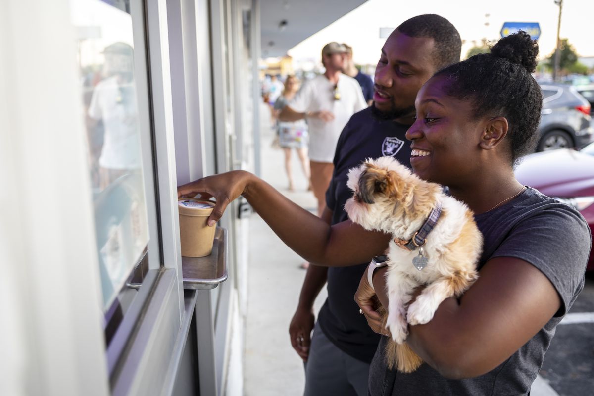 Reneé and Jonathan Omoyeni and their pup Mello pick up their ice cream order at Underground Creamery on Monday, Sept. 26, 2022.