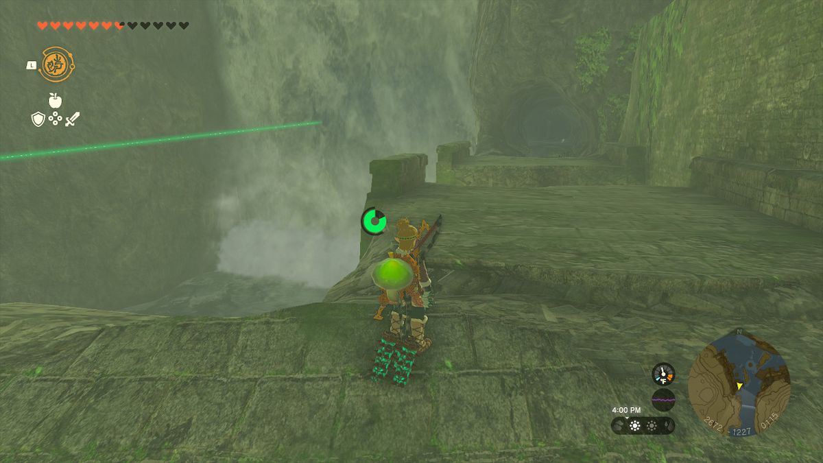 Link looking at an cave entrance that leads behind a waterfall. A green beam points toward it.