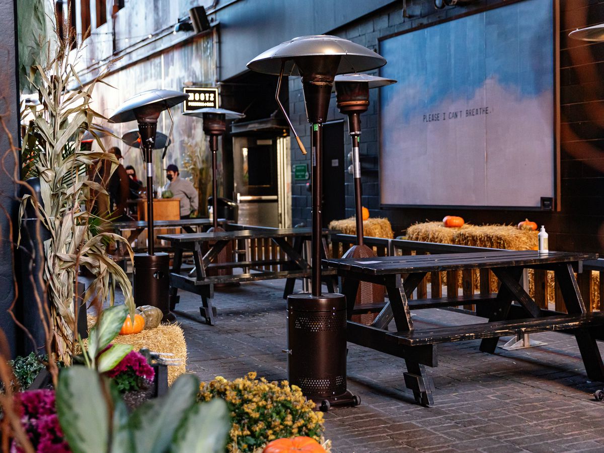 Picnic tables and heaters are surrounded by autumn decor at the Skip in the Belt Alley.