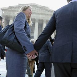 California's Proposition 8 plaintiffs Sandy Steir, center, holds hands with her partner Kris Perry, right, as they and Jeff Zarrillo, and Paul Katami, left, walk into the Supreme Court in Washington, Wednesday, June 26, 2013.  The Supreme Court is meeting to deliver opinions in two cases that could dramatically alter the rights of gay people across the United States. The justices are expected to decide their first-ever cases about gay marriage Wednesday in their last session before the court's summer break.