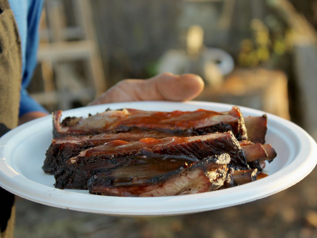 Close-up of smoked pork ribs on a white paper plate